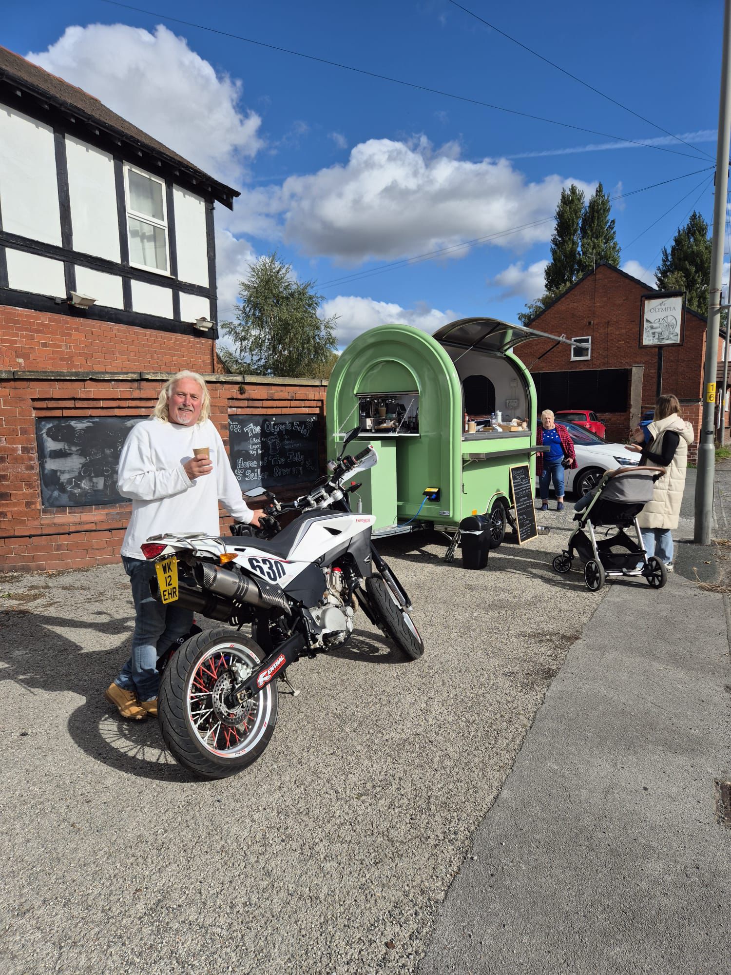 Smiling customer with his motorbike, enjoying a coffee from Molliccino's