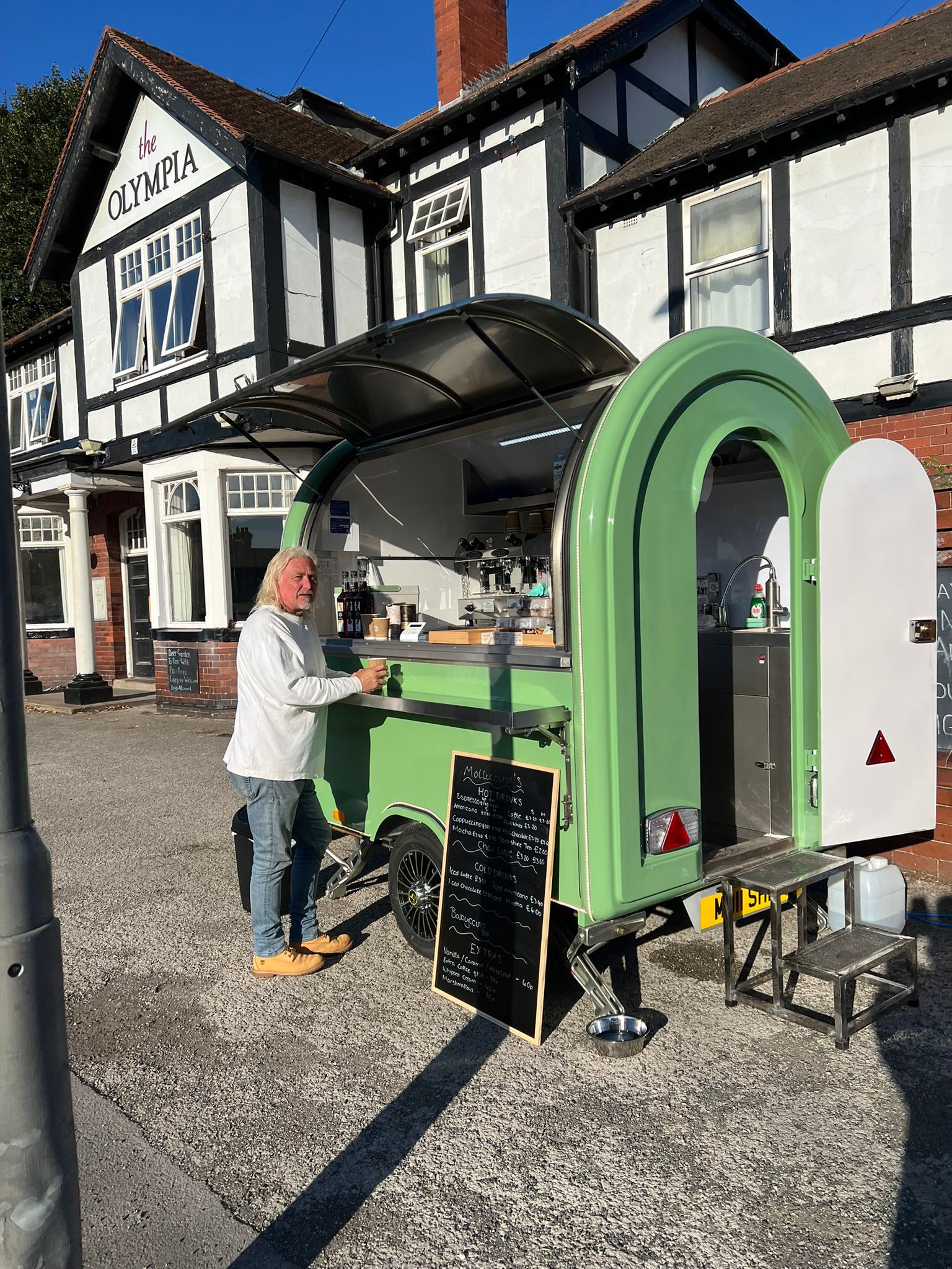 Molliccino's coffee trailer parked outside The Olympia pub with a customer